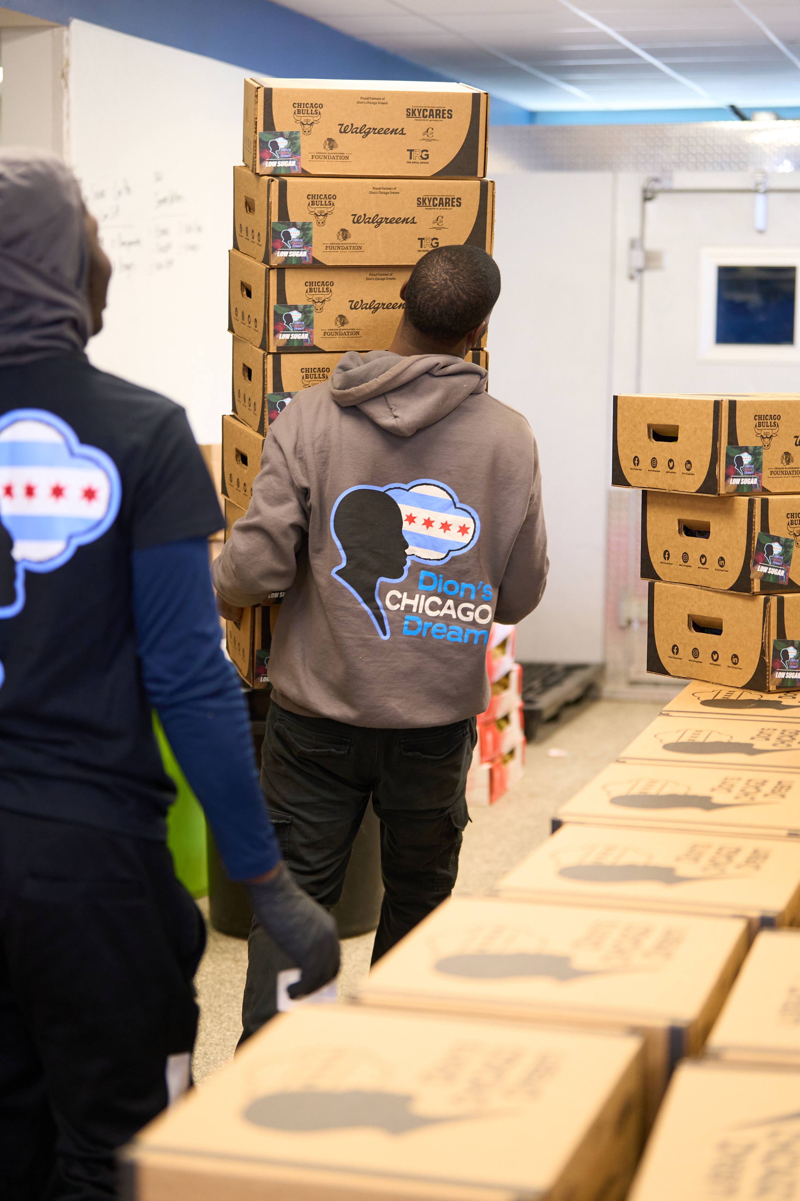 Dream Team members moving produce boxes with partner-branded packaging